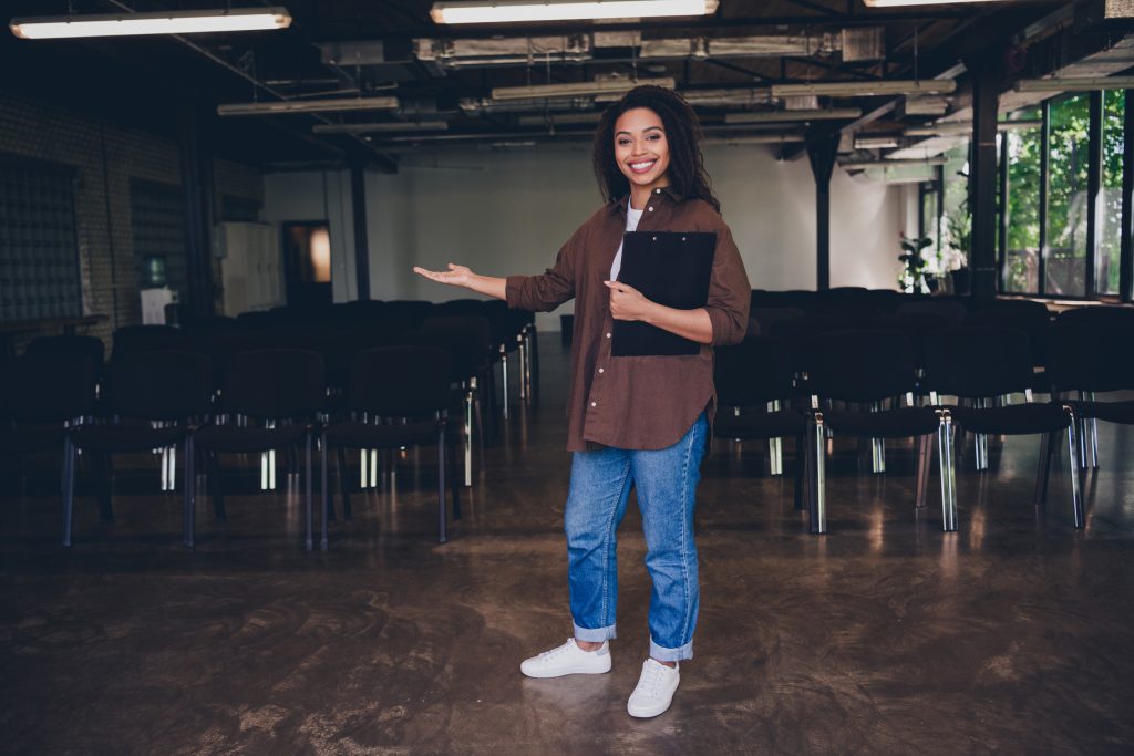 portrait of young woman clipboard show welcome you business school training conference room indoors